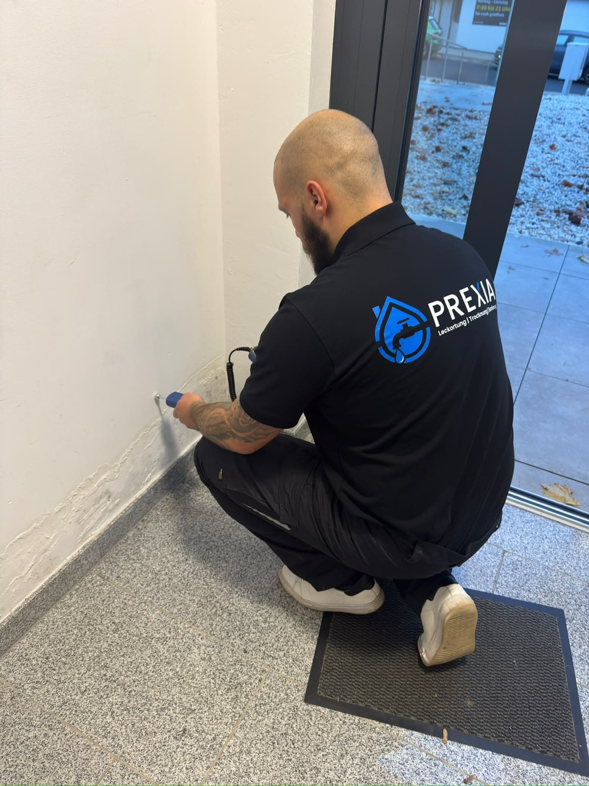 Vincent Prena bei der Leckortung vor Ort – Feuchtemessung an der Wand